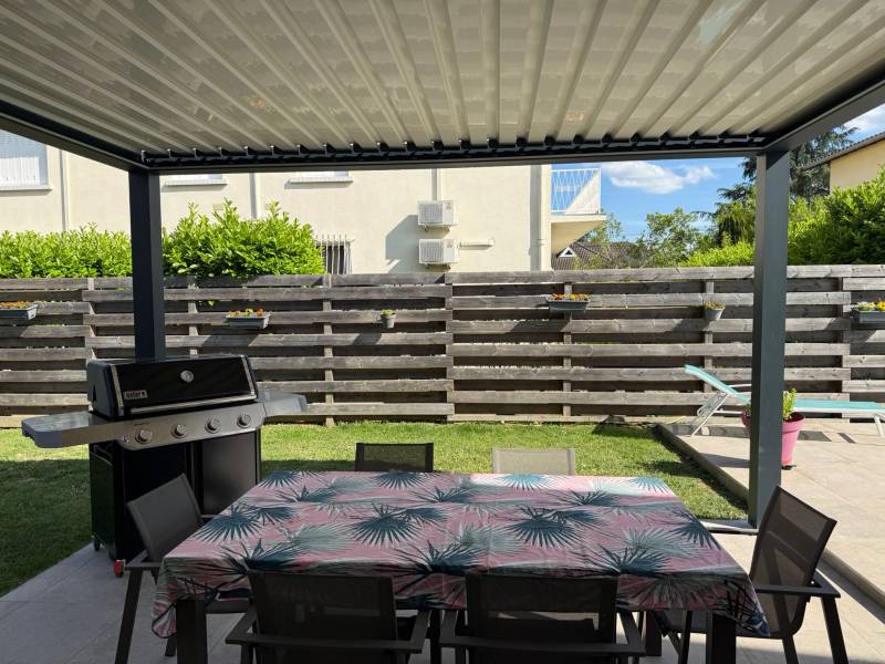 Vue intérieure pergola bioclimatique avec lames fermées – Espace repas extérieur protégé à Castelginest – Fourniture et pose assurées par Eco Fenêtres - Travaux possible à Balma, L'union, Toulouse ... 