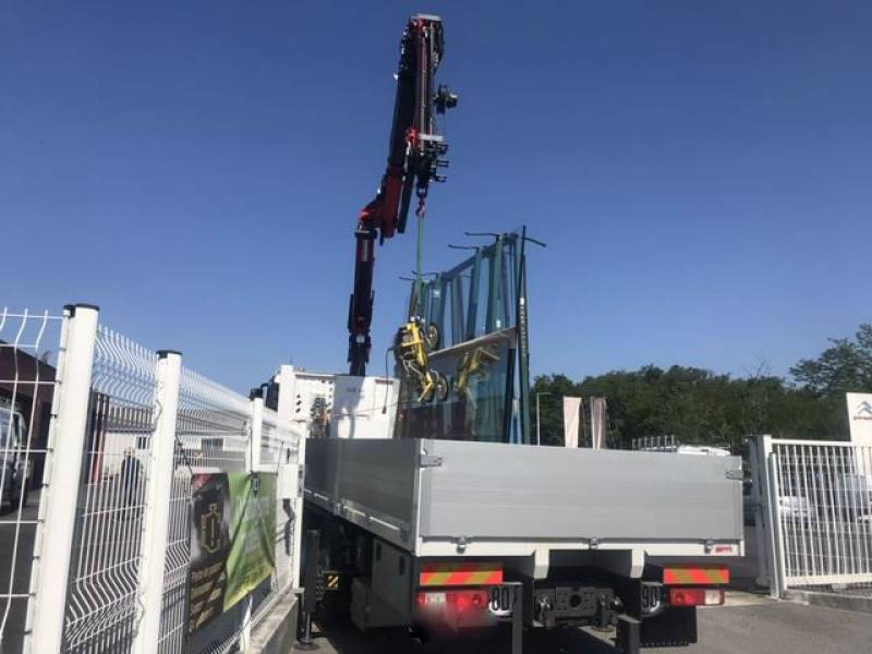 Livraison des vitrages par camion grue pour mise en place des verres sur vitrine de magasin en cours de réalisation