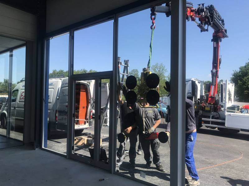 Pose des vitrages sur vitrine de magasin en cours de réalisation