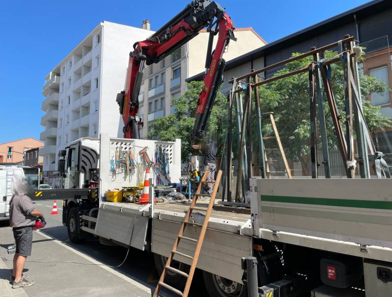 Mise en place du vitrage sécurit pour la nouvelle vitrine de magasin en aluminium sur mesure noir -  Réalisation Eco Fenêtres (31140)