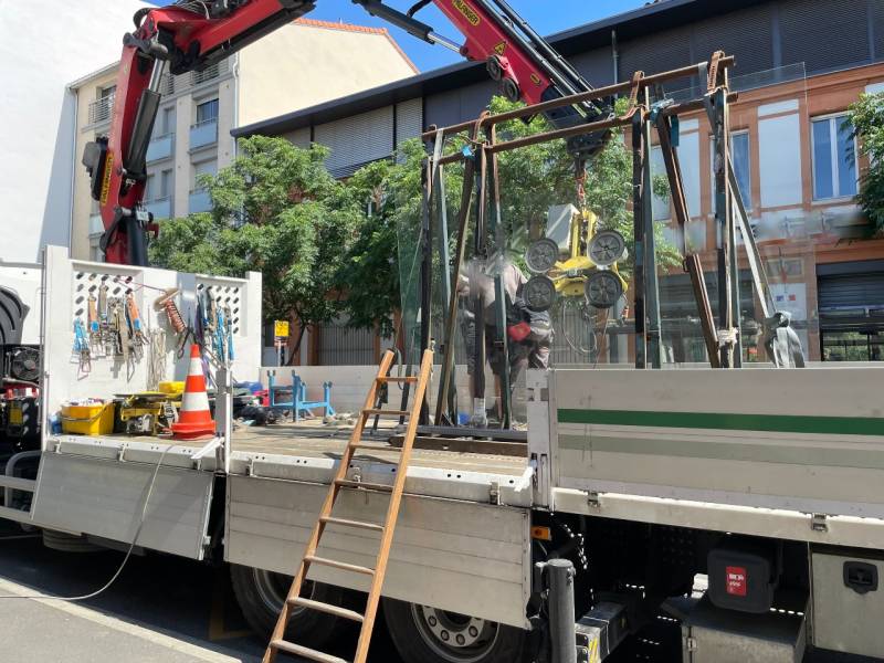 Installation du vitrage avec camion grue pour future vitrine en aluminium sur mesure - Installation faite par Eco Fenêtres (31140)
